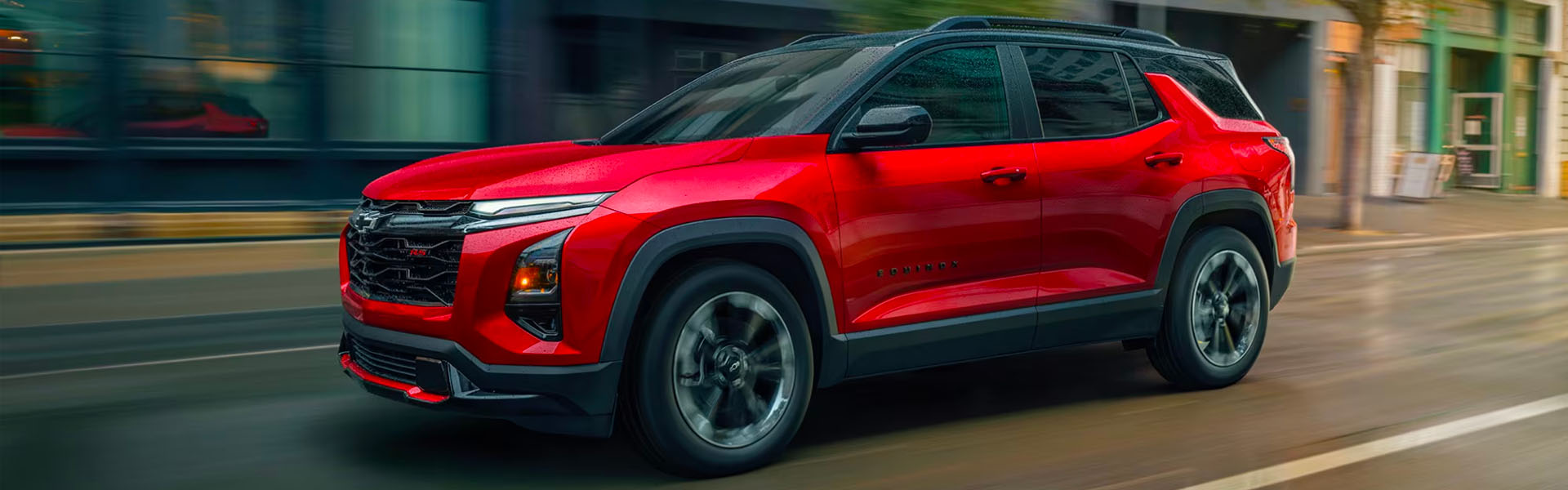 Red Chevrolet Equinox driving through the city.
