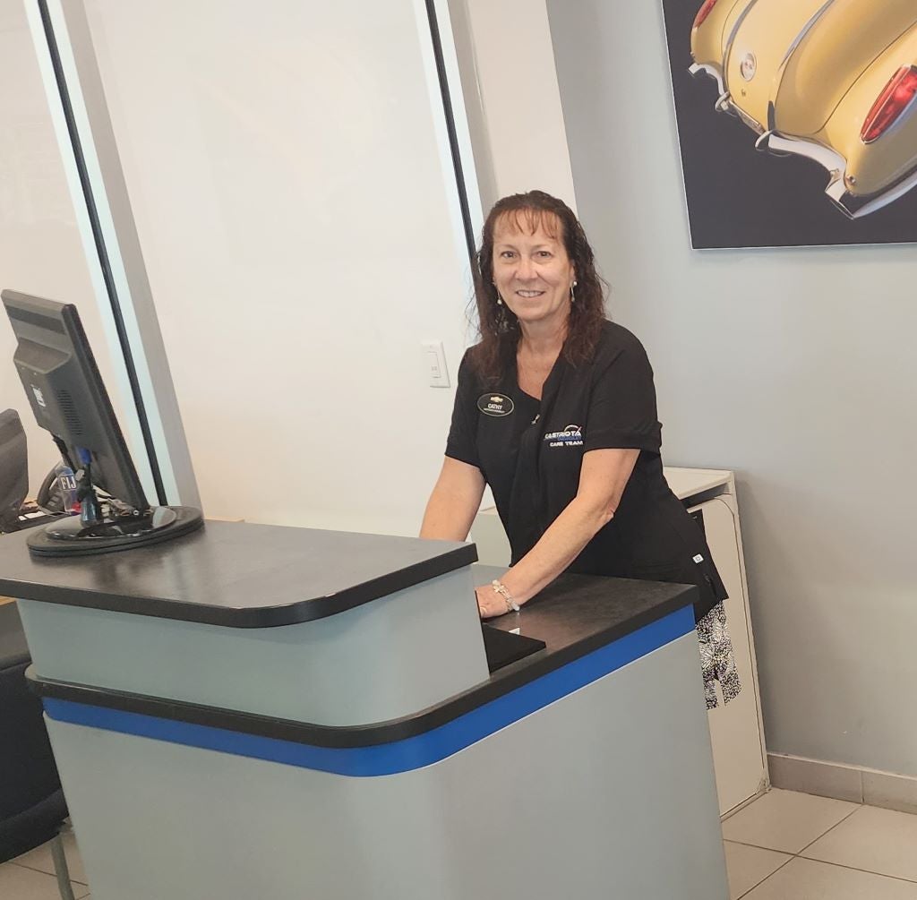 Kathy standing at front desk with computer monitor