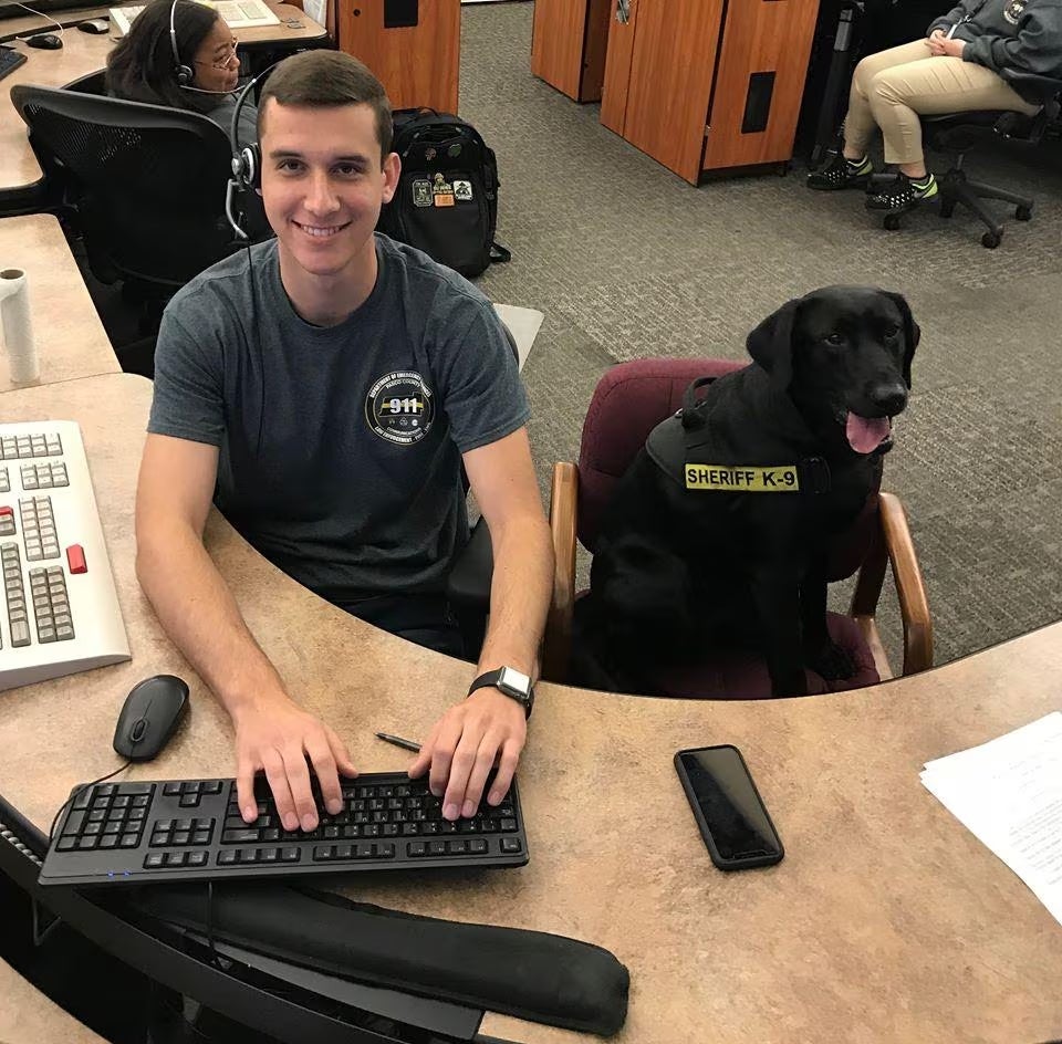 Man and a black dog at a desk